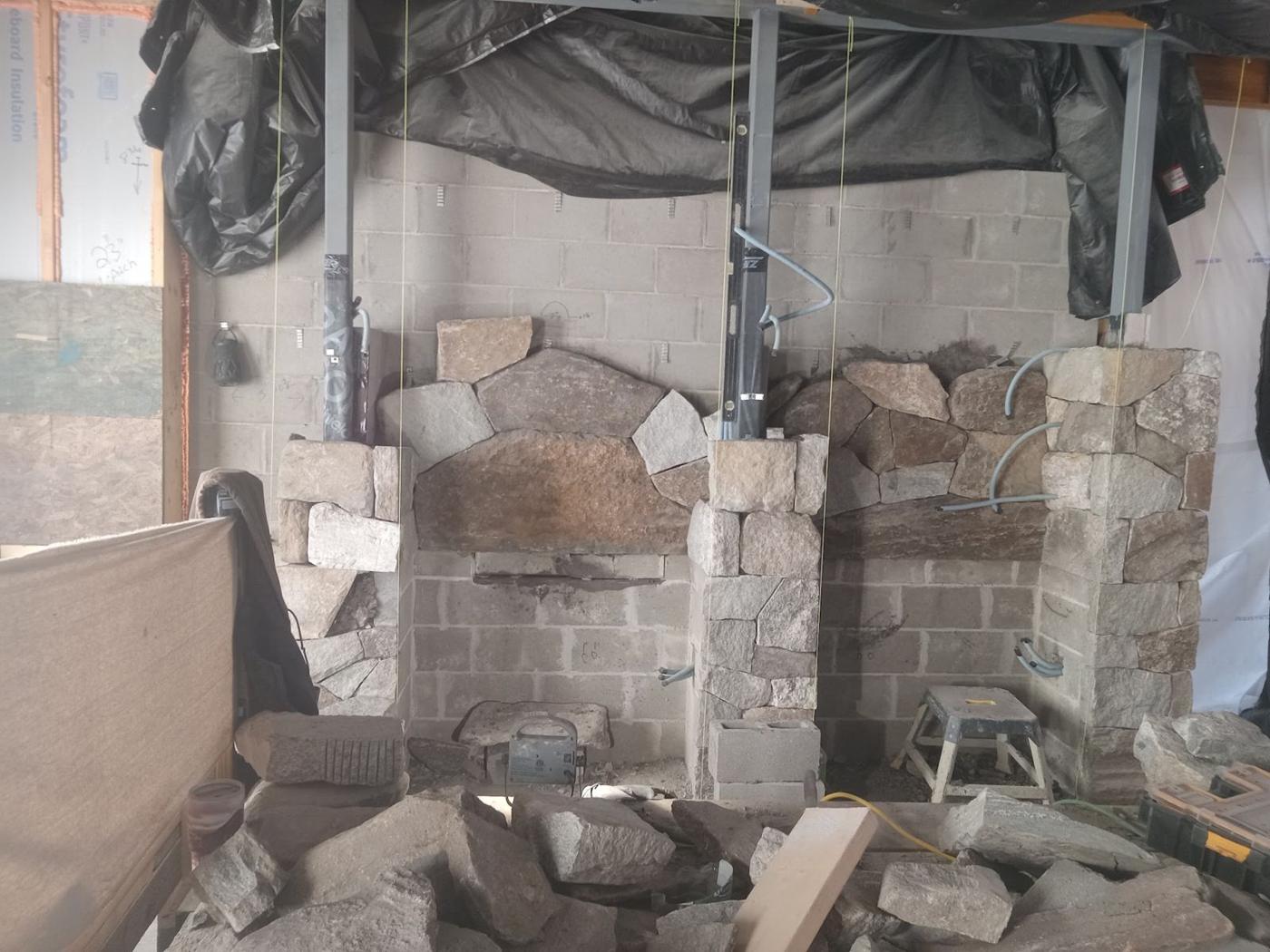 Stone fireplace being built inside a home under renovation
